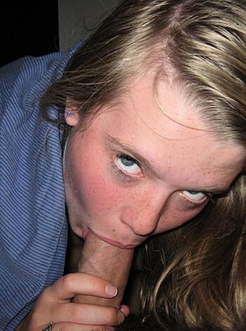 A busty blonde woman with her lips wrapped around a fat, veiny dick, eagerly slurping on it like a hungry baby, while the guy's hands grip onto her shoulders for support.