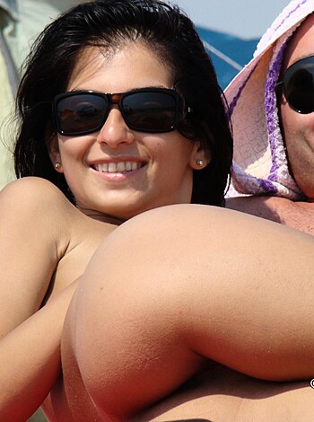 Fucking hot couple bummin' on the fuckin' sandy shore, both half-naked with shades. Chick got a rack n' all, and they're all smiles.