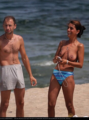 A guy and a chick in bikinis fucking at the shore, boning on the sandy dunes with their bodies exposed and wet from the surf, flaunting their firm butts while they grind their crotches together.