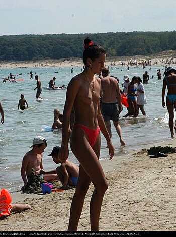 A fat, hairy dickhead strolls down the shore in bright-red speedos that barely cling to his portly ass.
