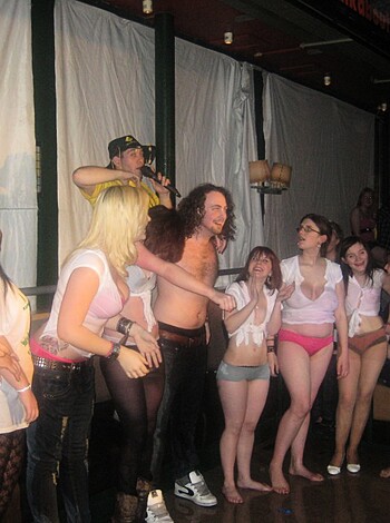 This picture depicts a bunch of fucking dudes, dressed in fucking pink and white assless chonies, standing uncomfortably near each other.