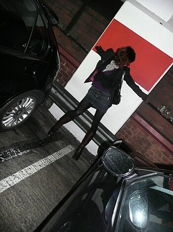 Vulgar, factual description of the image: "Look at this f*cking slutty b*tch trying to get some dick from passing drivers by stretching her arms outside the car."