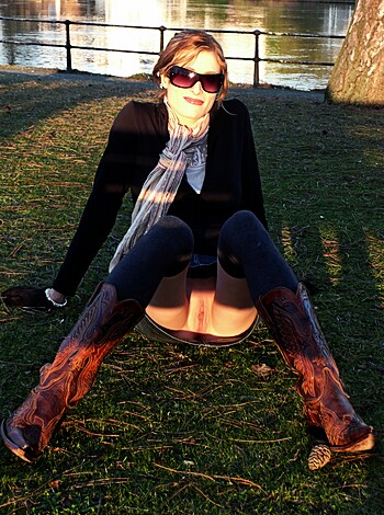 Here is a photo of a hot bitch with big tits and shapely legs posing outside while wearing sexy boots.