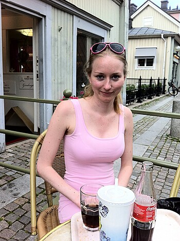 Sitting in pink, ass-fucking sweet dress on table.
