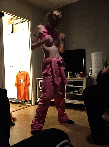 A busty blonde in pink lacy underwear grabbing at her tits like she's on a fuckin' Playboy shoot or somethin'.