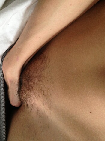 A dude's junk, with him gripping it while he's nekkid from the waist down, sportin' some bush on his nutsack and boxers covering his goods.