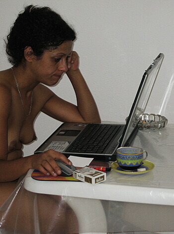 Here's a fuckin' picture of some naked chick sittin' at a goddamn table with no clothing whatsoever.