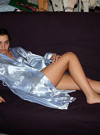 A naked broad is lying on the sofa with her legs open, giving you a good look at her pussy and thighs.