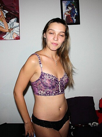 A busty broad in a lilac brassiere and thong undies stands before you, with her legs spread wide.