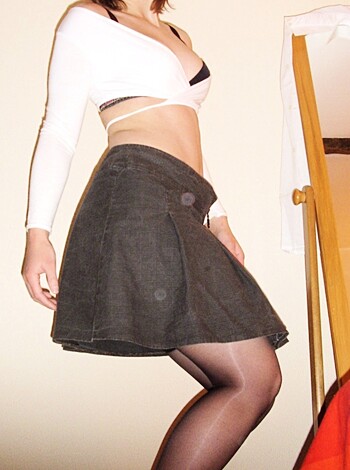 The fuckin' bitch is standin' with her ass stickin' outta those tight pantyhose, showin' off her fuckin' smooth skin in that little white skirt like a friggin' tease.