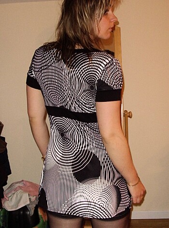 Image depicting an attractive bitch clad in a checkered skirt that is too fucking short, paired with a brazen top that showcases her ample tits, giving the viewer a goddamn eyeful of her luscious cleavage.