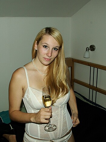 The photo shows a naked chick with a tight bra and hot ass who’s holding a champagne flute, looking sexy as fuck.