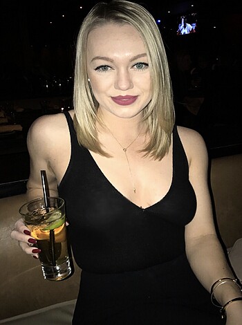 A slutty-ass bitch sippin' on some fruity ass drink while she sits her tits up on the bar counter.