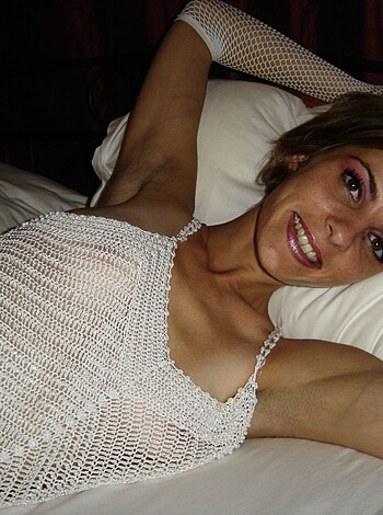 A horny bitch in her sexy underwear spreading her legs on the bed, exposing her naked ass and pussy while flashing a grin at the lens.