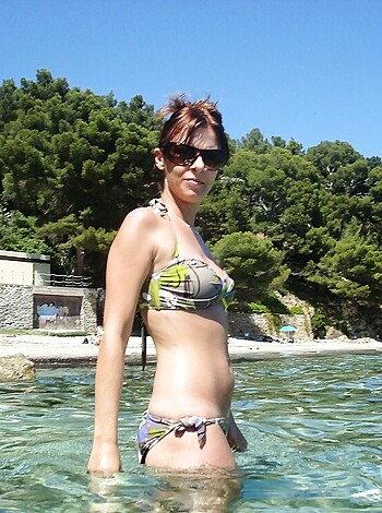 Here's a fucking picture of a chick tits deep in the motherfucking ocean, sportin' a skimpy-ass bikini like she don't give a shit.
