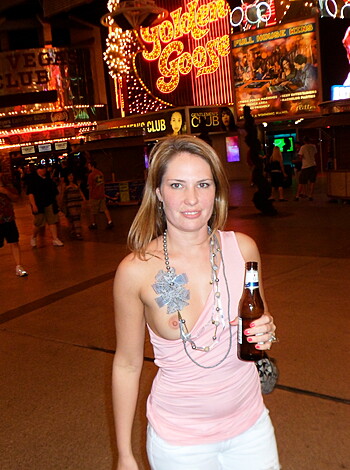 A slutty bimbo flashing her tits while holding two cans of beer for the dudes to see.
