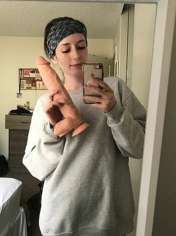 Woman taking pink dildo selfie while ass out.