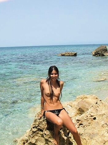 Fucking hot chick with her tits out, basking in the sun by the fucking sea.