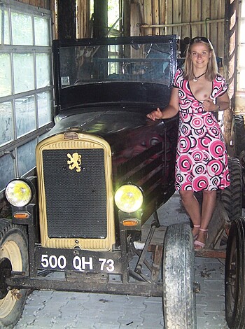 Vulgar and factual description: "Fucking hot chick posing next to an old rusty pickup truck."
