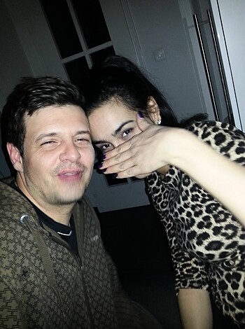 "Smiling young couple fucking in dimly lit background."