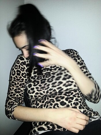 "Busty bitch with big tits chatting on her phone while posing seductively in a fuckable animal-print shirt, showing off her juicy melons."