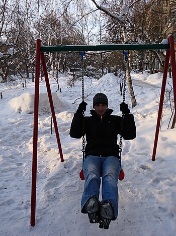 Look at this fuckin' idiot trying to have fun on a goddamn swing set during the godforsaken winter season, when it's freezin' outside and there's snow all over the place. What the hell is wrong with people?