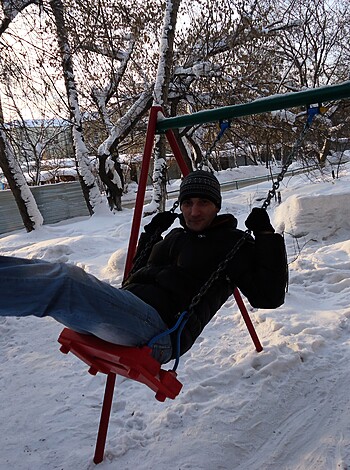 The guy is jerking off on a snow-covered playground bench, his dick and balls hanging out for all to see.