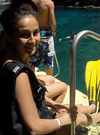 Woman with scuba gear and wetsuit shows her cocksucker teeth for a photo shoot.