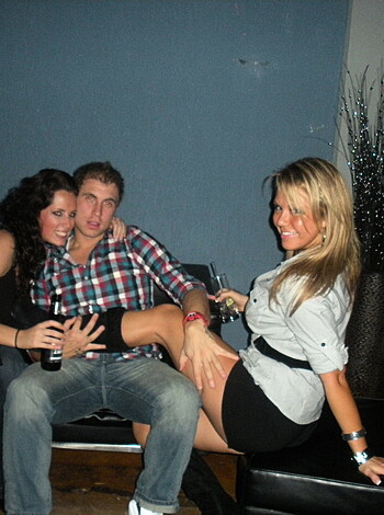 Three people stand by and laugh as a horny couple sucks face in public.