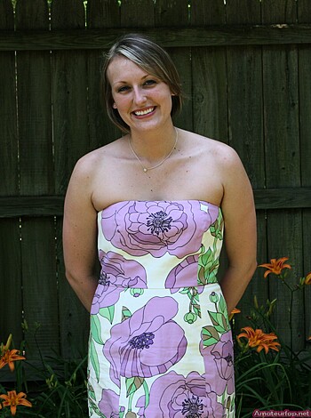 This here bitch is wearin' a fuckin' flowery dress while posing for the camera.