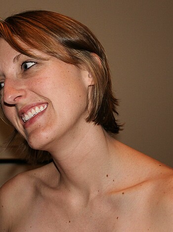 "A bare-boobed babe smirking."