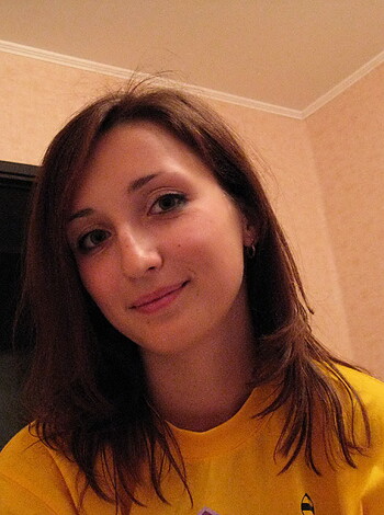 "Hot, busty broad with big tits and yellow tank top grinning like she just sucked a cock."