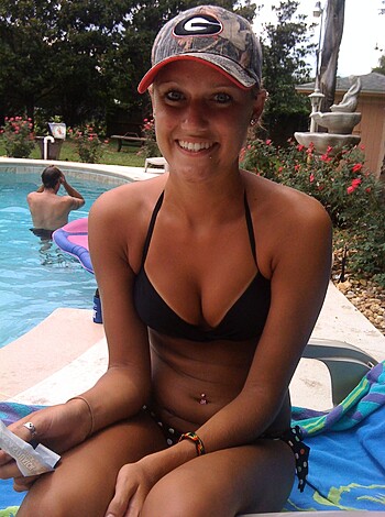 Here's a hot ass blonde bitch lounging by a pool in some skimpy bikini shit, showing off her fuckin tits and ass, while giving us a dumb smirk. Goddamn, this chick looks like she knows how to have a good time under the sun!