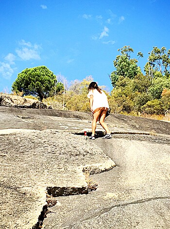 "Sexy lady scaling rough rocks with sunshine bouncing off her tits."