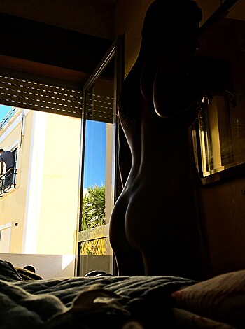 Look at this fucking picture, it's a goddamn nude ass dude staring out a fucking window. What the hell is he even doing? Maybe he just got laid and wants to watch the sunrise while jerkin' off like some kinda dirty pervert. I mean, come on now, who does that shit? Oh yeah, fucking everyone I guess. God damn it.