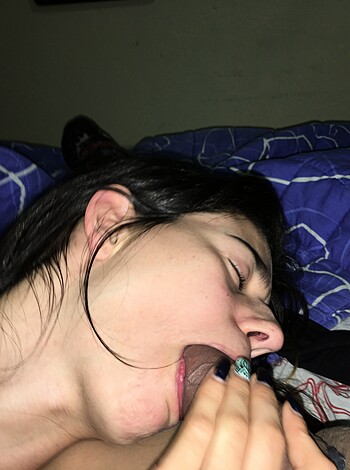 Here's an image of a busty blonde chick, fingers buried deep into her pussy as she lies on the bed, eyes closed and face contorted with intense pleasure.