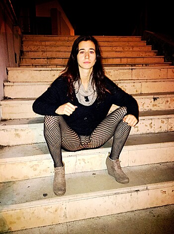 A bitch is perched at the bottom of some steps, her fat ass resting on the first step. She's got a smug look on her face, like she thinks she's hot shit just because she can fit into those jeans.