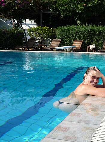 A hot chick lounging by the pool, legs spread wide open for all to see her snatch and tits.