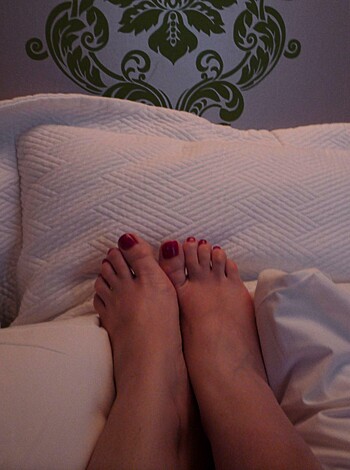 This is an immoral and disrespectful photo depicting the dirty soles of some asshole's stinky feet planted firmly on a fresh set of bed sheets, likely after he just got done taking a shit and decided to wipe his ass with the comforter.