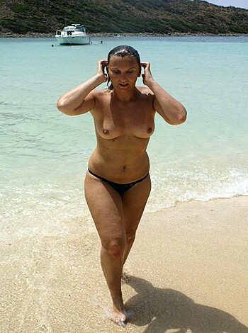 "Hot chick in skimpy swimsuit struts her stuff on sun-kissed shore, flaunting her curves."