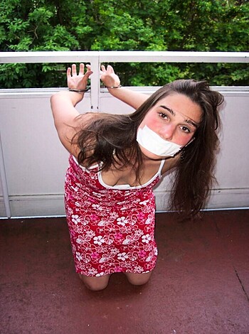 Here's a bitch with her fuckin' mouth covered in duct tape, dressed like a fucking whore.