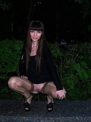 A naked ass of a sexy bitch with stilettos, lying on her knees with a black dress on.