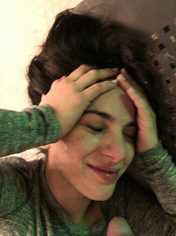 A chick is laying topless on her back with her hands covering her eyes and mug.