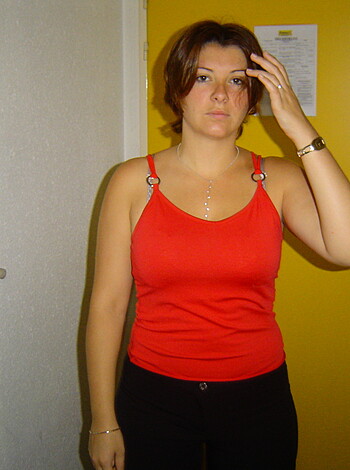 "Here's the fuckin' shot of that smokin' hot chick in the red top and black pants with her hand on her hairy tits, standing by the fuckin' door."