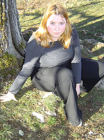 Here's a fuckin' picture of some bitch sittin' on the grass and leaning against a tree with her tits hangin' out.